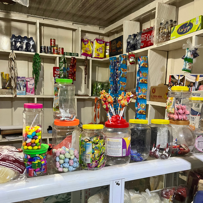 Sweets and snacks displayed on shelves in a small store.